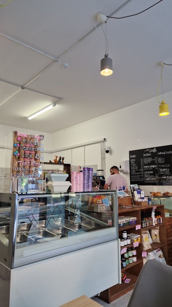 Inside the cafe, looking towards the counter under pendant lights.